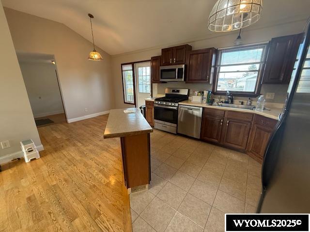 221 Fir St, Buffalo, WY 82834 - kitchen with appliances with stainless steel finishes, a sink, lofted ceiling, light countertops, and baseboards