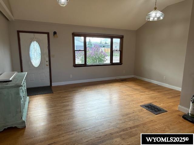 221 Fir St, Buffalo, WY 82834 - entryway with healthy amount of natural light, lofted ceiling, wood finished floors, and baseboards