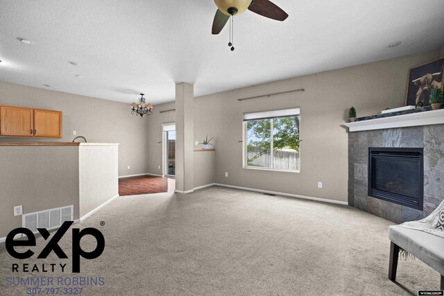 2521 Sagewood Ave, Casper, WY 82601 - unfurnished living room with carpet flooring, a chandelier, a tile fireplace, and baseboards