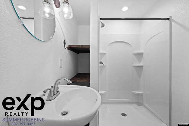 2521 Sagewood Ave, Casper, WY 82601 - bathroom with a textured wall, a shower stall, recessed lighting, and a sink