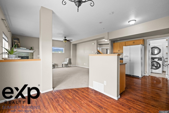 2521 Sagewood Ave, Casper, WY 82601 - kitchen featuring white refrigerator with ice dispenser, stacked washer / dryer, ceiling fan, brown cabinets, and open floor plan