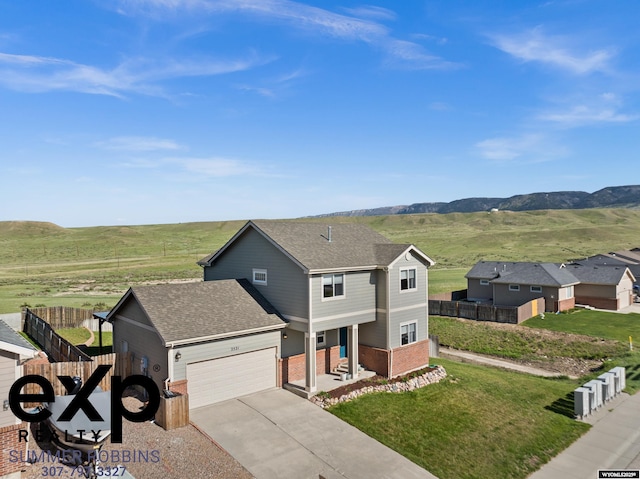 2521 Sagewood Ave, Casper, WY 82601 - traditional-style house featuring brick siding, a garage, driveway, roof with shingles, and a mountain view