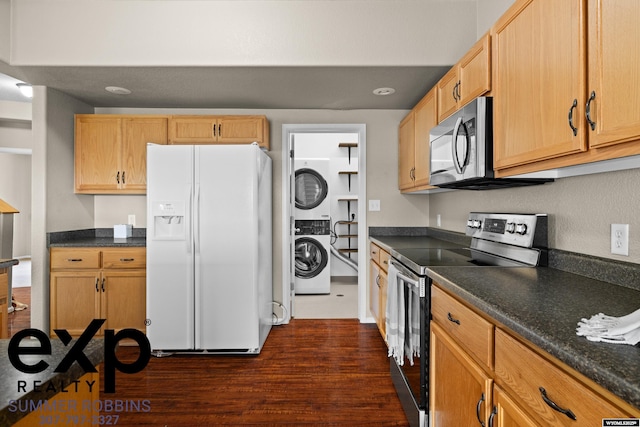 2521 Sagewood Ave, Casper, WY 82601 - kitchen with stainless steel appliances, estacked washer and dryer, dark countertops, and dark wood-style floors