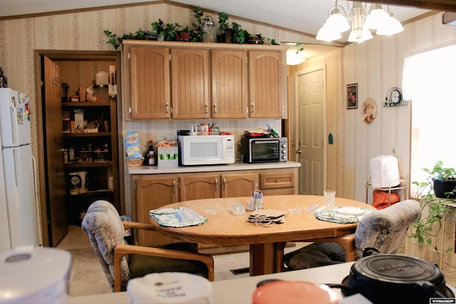 SPACE10 50 S Colorado Ave, Guernsey, WY 82214 - kitchen with wallpapered walls, white appliances, crown molding, light countertops, and a chandelier