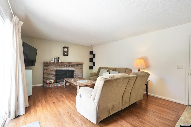 4451 S David St, Casper, WY 82601 - living area featuring light wood-type flooring, a brick fireplace, and baseboards
