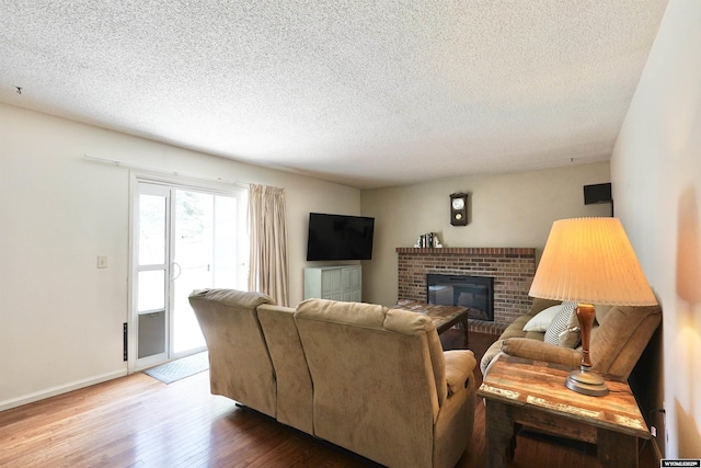 4451 S David St, Casper, WY 82601 - living room with wood-type flooring, a fireplace, baseboards, and a textured ceiling