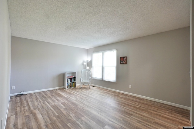 4451 S David St, Casper, WY 82601 - empty room with wood finished floors, a textured ceiling, and baseboards