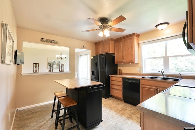 4451 S David St, Casper, WY 82601 - kitchen featuring black appliances, a sink, a chandelier, a ceiling fan, and light countertops
