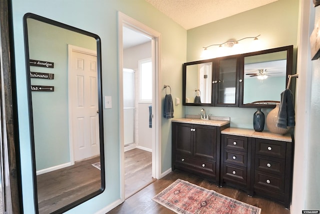 4451 S David St, Casper, WY 82601 - full bath with wood finished floors, vanity, baseboards, and a textured ceiling