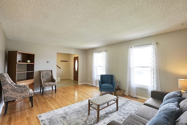 4451 S David St, Casper, WY 82601 - living room featuring wood finished floors, a textured ceiling, stairway, and baseboards