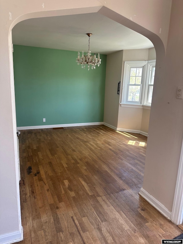 101 9th, Sinclair, WY 82334 - empty room with arched walkways, wood finished floors, and a chandelier