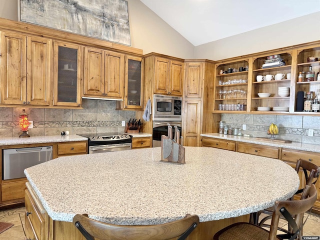 617 Lucille Cir, Evanston, WY 82930 - kitchen with stainless steel appliances, lofted ceiling, open shelves, a kitchen breakfast bar, and backsplash