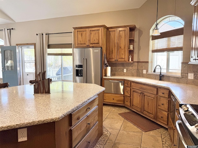 617 Lucille Cir, Evanston, WY 82930 - kitchen with a sink, appliances with stainless steel finishes, brown cabinets, and decorative backsplash