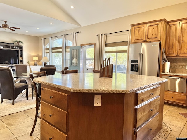 617 Lucille Cir, Evanston, WY 82930 - kitchen with high end refrigerator, open floor plan, a kitchen island, light tile patterned flooring, and decorative backsplash
