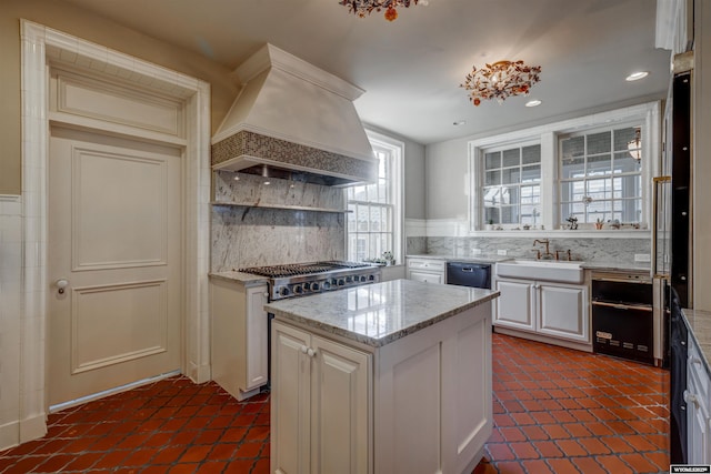 1108 S Wolcott St, Casper, WY 82601 - kitchen with custom exhaust hood, a sink, white cabinetry, tasteful backsplash, and recessed lighting