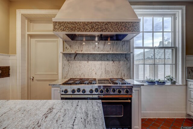 1108 S Wolcott St, Casper, WY 82601 - kitchen with custom exhaust hood, range with two ovens, light stone counters, and plenty of natural light
