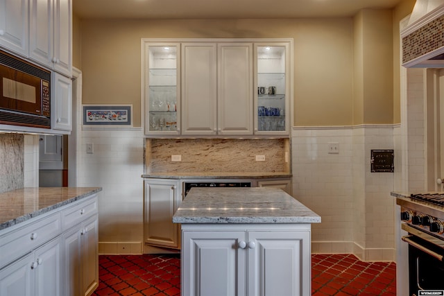 1108 S Wolcott St, Casper, WY 82601 - kitchen featuring black microwave, tile walls, white cabinets, glass insert cabinets, and a wainscoted wall