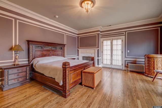 1108 S Wolcott St, Casper, WY 82601 - bedroom with radiator, ornamental molding, a decorative wall, wood finished floors, and a fireplace