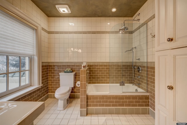 1108 S Wolcott St, Casper, WY 82601 - bathroom with tile walls, toilet, tiled shower / bath, and tile patterned floors