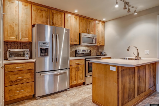 1108 S Wolcott St, Casper, WY 82601 - kitchen featuring appliances with stainless steel finishes, a sink, backsplash, light countertops, and brown cabinets