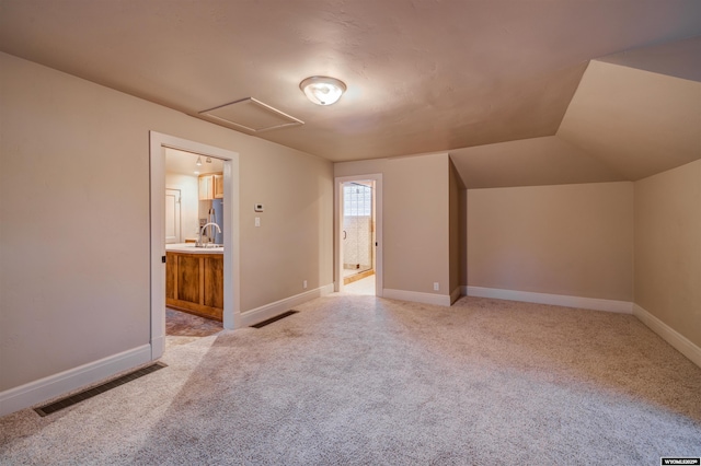 1108 S Wolcott St, Casper, WY 82601 - bonus room featuring light carpet, attic access, baseboards, and vaulted ceiling