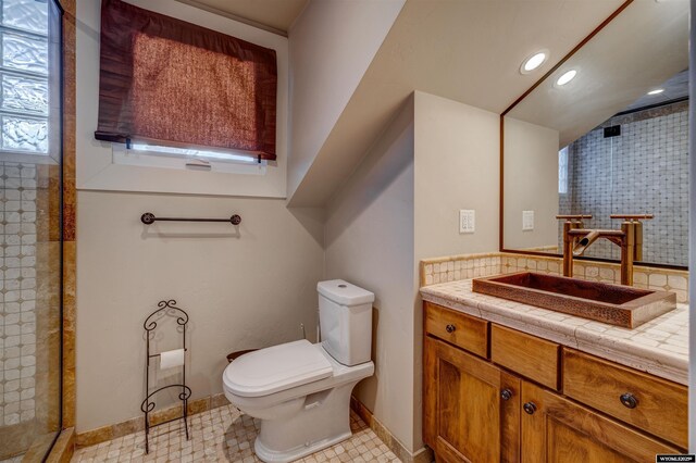 1108 S Wolcott St, Casper, WY 82601 - bathroom with toilet, vanity, a tile shower, recessed lighting, and baseboards