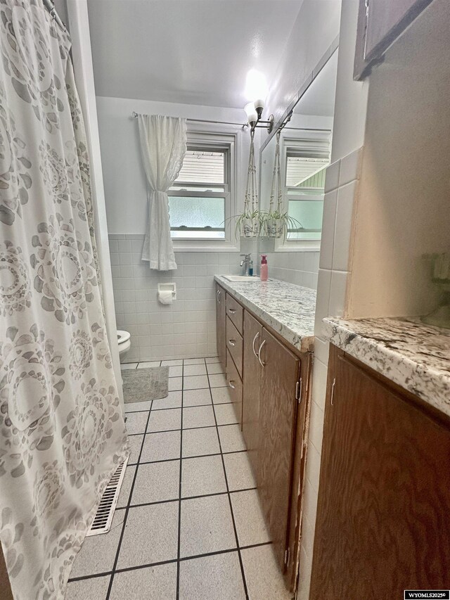 720 S 16th St, Worland, WY 82401 - full bathroom with tile walls, vanity, tile patterned floors, toilet, and wainscoting