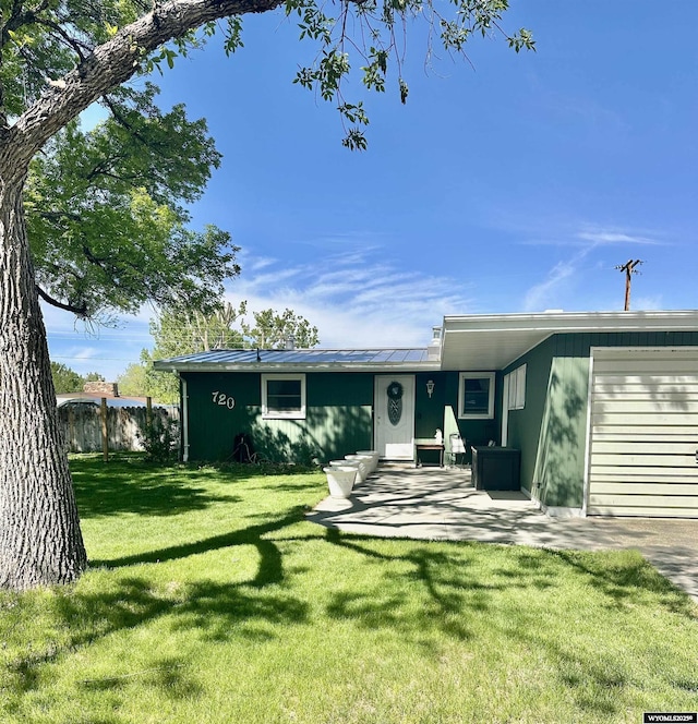 720 S 16th St, Worland, WY 82401 - view of front of property featuring roof mounted solar panels, a garage, and metal roof