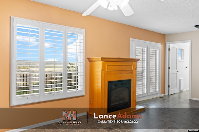 396 Williams Way, Glenrock, WY 82637 - unfurnished living room with baseboards, a fireplace with raised hearth, a ceiling fan, a textured ceiling, and tile patterned floors
