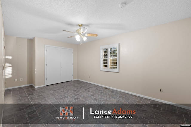 396 Williams Way, Glenrock, WY 82637 - unfurnished bedroom with a textured ceiling, ceiling fan, and baseboards