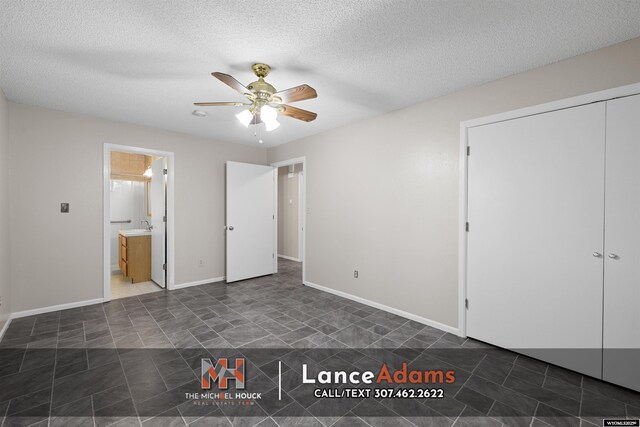 396 Williams Way, Glenrock, WY 82637 - unfurnished bedroom featuring a textured ceiling, ceiling fan, tile patterned flooring, a closet, and connected bathroom