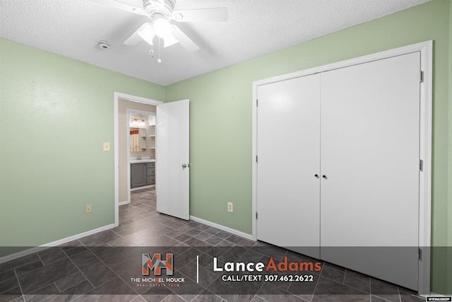 396 Williams Way, Glenrock, WY 82637 - unfurnished bedroom with dark tile patterned floors, baseboards, a closet, a textured ceiling, and ceiling fan