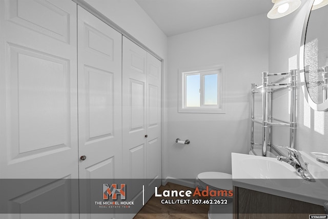 396 Williams Way, Glenrock, WY 82637 - bathroom with a closet, vanity, toilet, wood finished floors, and baseboards