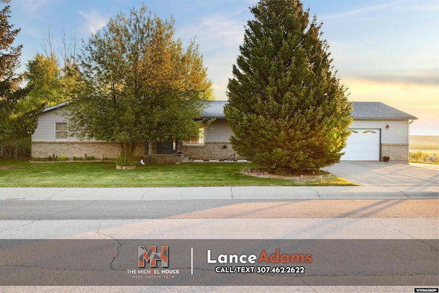 396 Williams Way, Glenrock, WY 82637 - view of property hidden behind natural elements with brick siding, a garage, concrete driveway, and a front yard
