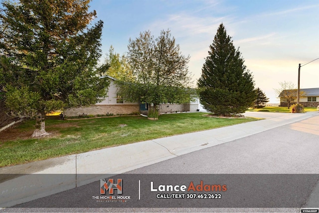 396 Williams Way, Glenrock, WY 82637 - obstructed view of property featuring a front yard and brick siding