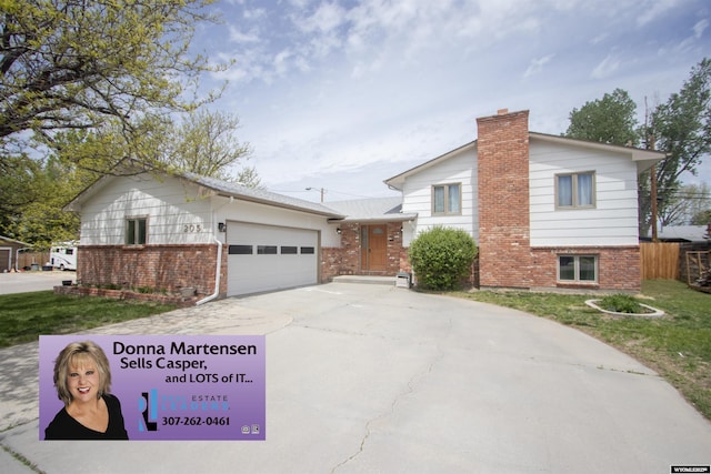 205 Daffodil, Casper, WY 82604 - split level home with brick siding, driveway, an attached garage, and a chimney