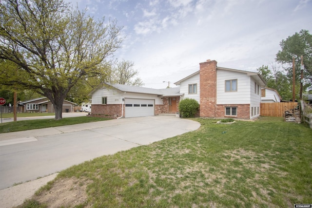 205 Daffodil, Casper, WY 82604 - split level home featuring brick siding, concrete driveway, an attached garage, and a chimney