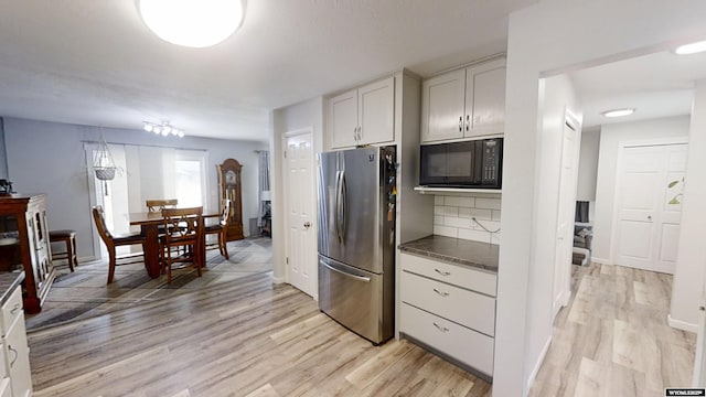 205 Daffodil, Casper, WY 82604 - kitchen featuring freestanding refrigerator, black microwave, light wood-type flooring, and backsplash