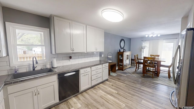 205 Daffodil, Casper, WY 82604 - kitchen featuring freestanding refrigerator, dishwasher, tasteful backsplash, light wood finished floors, and white cabinets