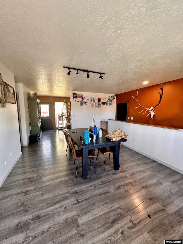 1595 S Riverbend Dr, Green River, WY 82935 - dining space featuring a textured ceiling, wood finished floors, rail lighting, and baseboards