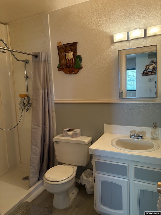 715 Emerald St, Kemmerer, WY 83101 - bathroom with toilet, vanity, a stall shower, and wood finished floors