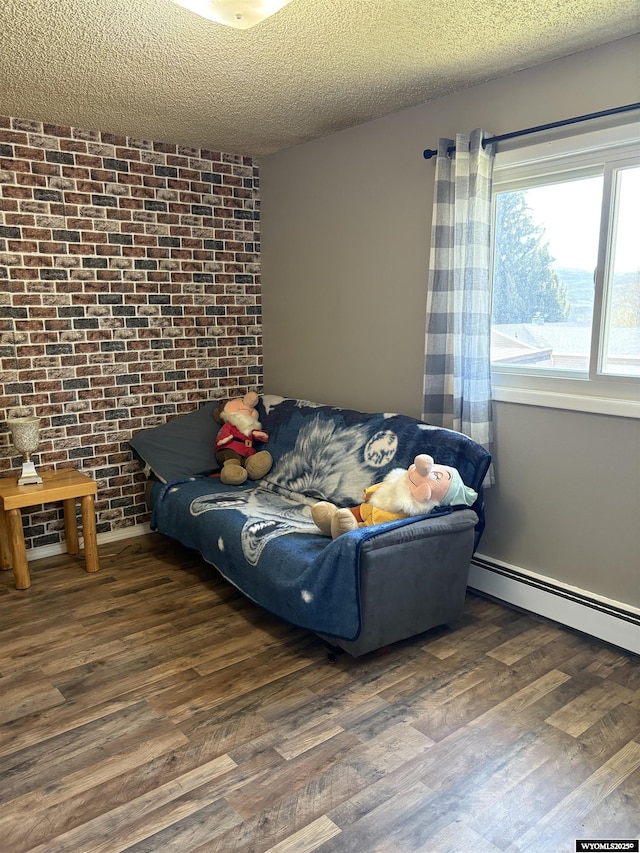 715 Emerald St, Kemmerer, WY 83101 - bedroom featuring wood finished floors, brick wall, a textured ceiling, and a baseboard radiator