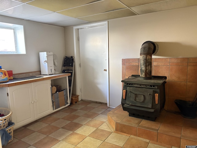 715 Emerald St, Kemmerer, WY 83101 - kitchen featuring white cabinetry, a wood stove, and light countertops