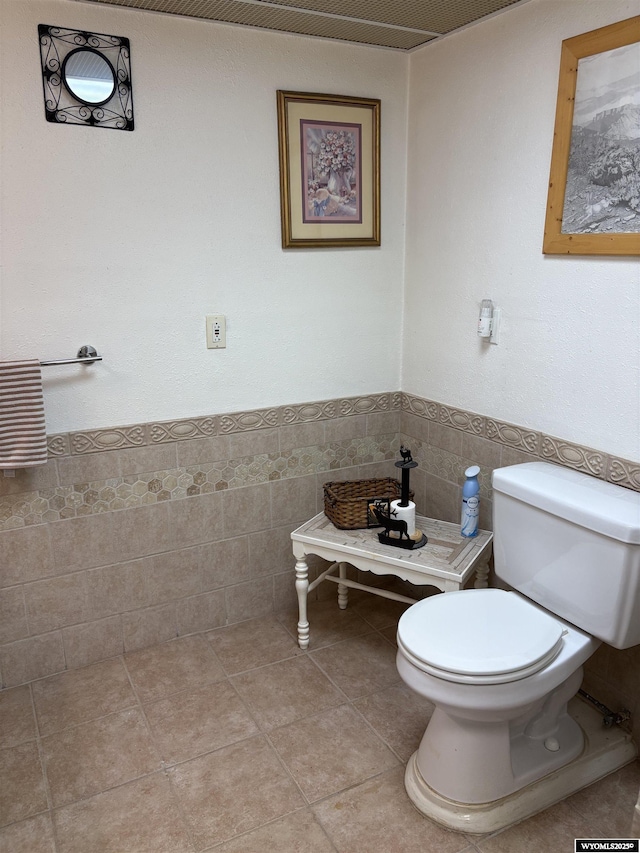 715 Emerald St, Kemmerer, WY 83101 - bathroom featuring toilet, tile walls, and wainscoting