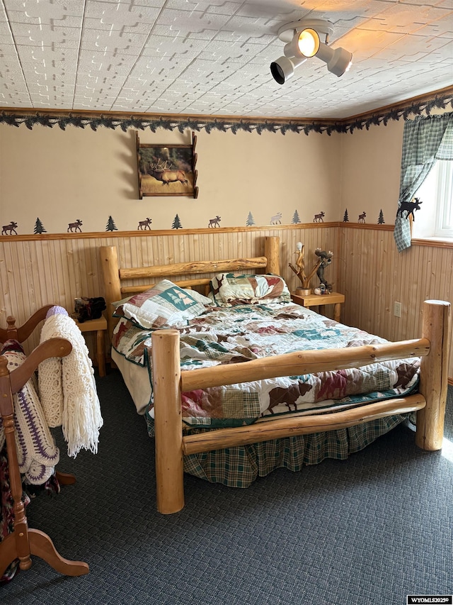 715 Emerald St, Kemmerer, WY 83101 - carpeted bedroom with wooden walls and a wainscoted wall