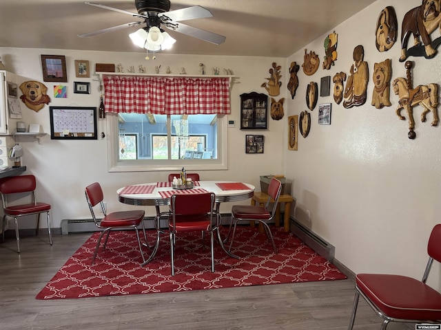 715 Emerald St, Kemmerer, WY 83101 - dining space featuring a baseboard heating unit, wood finished floors, ceiling fan, and baseboards