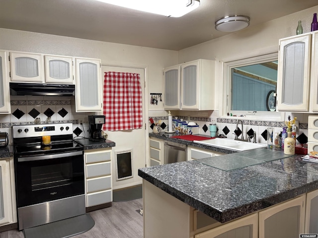 715 Emerald St, Kemmerer, WY 83101 - kitchen featuring appliances with stainless steel finishes, under cabinet range hood, a sink, and backsplash
