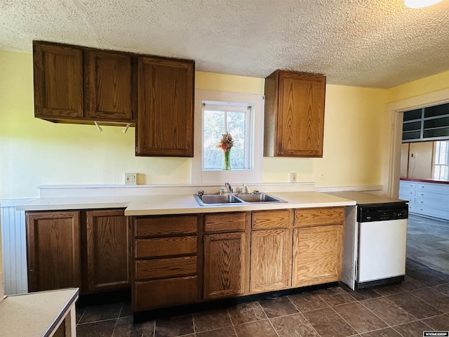 596 Garfield St, Lander, WY 82520 - kitchen featuring white dishwasher, a sink, light countertops, and a textured ceiling