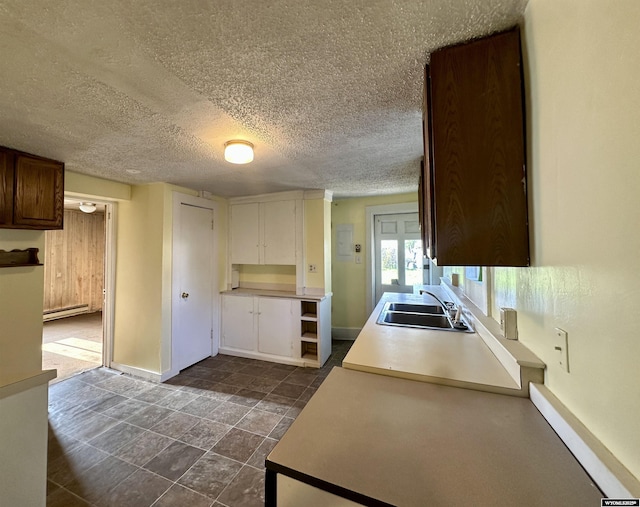596 Garfield St, Lander, WY 82520 - kitchen featuring a sink, baseboards, a textured ceiling, and baseboard heating