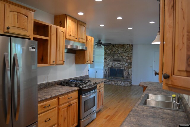 104 First St, Mountain View, WY 82939 - kitchen featuring stainless steel appliances, under cabinet range hood, a ceiling fan, dark countertops, and a sink